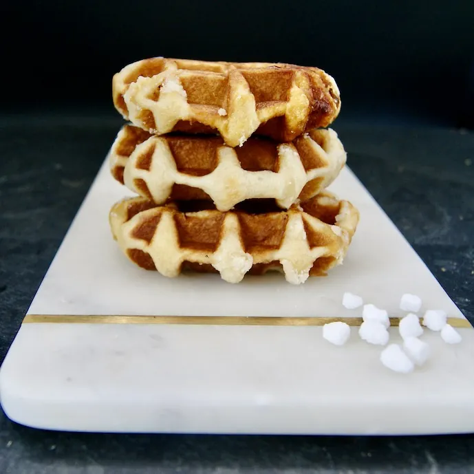 Tres waffles de Lieja apilados sobre una tabla de mármol